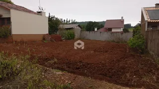 Vista externa de uma propriedade com terreno aberto e muros de vedação.