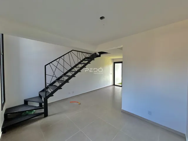 Hall de entrada com escadaria preta em um imóvel em Lajeado.