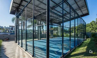 Vista externa de uma área coberta com estrutura de metal e vidro.