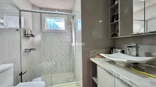 Banheiro com box de vidro e vaso sanitário.