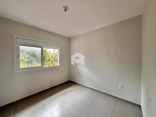 Ambiente interno de uma sala com piso de cerâmica e janela.