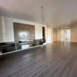 Ambiente interno com piso de madeira escura e paredes claras.