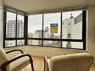 Vista da sala com grandes janelas que oferecem uma vista da cidade.