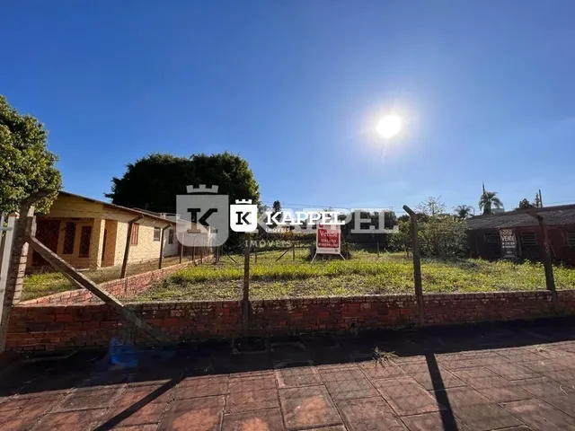 Foto da fachada de uma residência com muro de tijolos e gramado sob luz solar intensa.