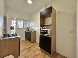 Sala de estar com piso de madeira e móveis planejados.