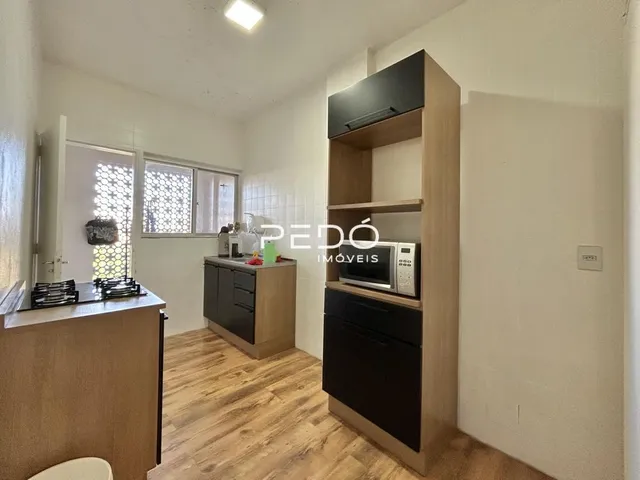 Sala de estar com piso de madeira e móveis planejados.