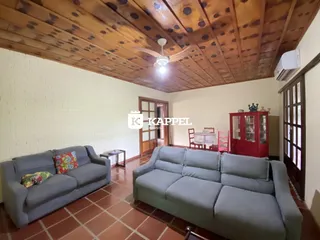 Sala de estar com sofá cinza e piso de cerâmica.