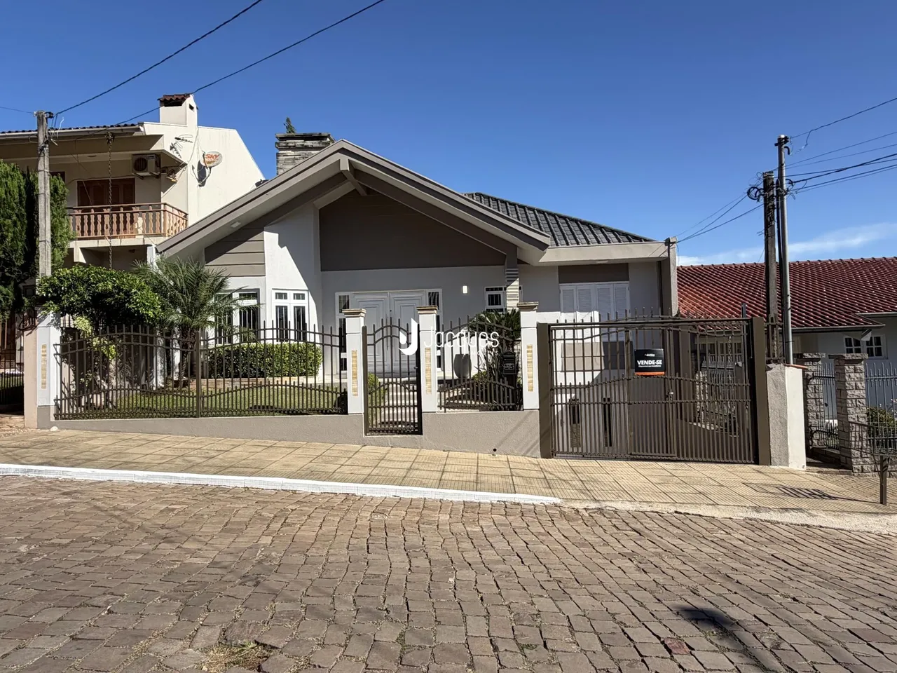 Fachada de uma residência em Lajeado, Brasil, com muro e portão de ferro.