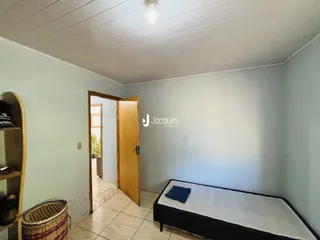 Quarto com cama e porta de madeira em uma residência.