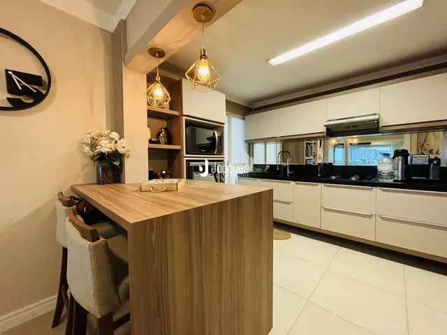 Ambiente moderno de cozinha e sala com ilha em Lajeado.