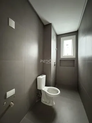 Foto de um banheiro moderno com paredes cinzas e um vaso sanitário branco.