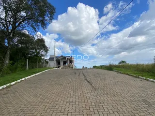 A foto mostra a fachada de uma casa em Lajeado, Brasil, com uma estrada de paralelepípedos em primeiro plano.