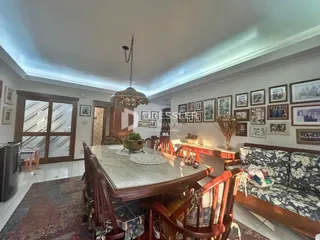 Ambiente interno de uma sala de jantar com mesa de madeira e decoração de parede.