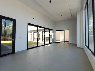 Sala de estar moderna com grandes portas de vidro que dão acesso ao exterior.
