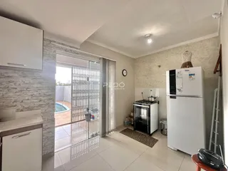 Interior de uma sala de estar com porta de vidro que dá para um pátio.