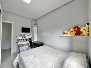 Quarto com cama e guarda-roupa em um ambiente claro.