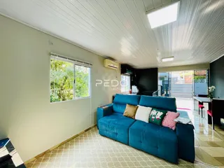 Sala de estar com sofá azul e grande janela de vidro.
