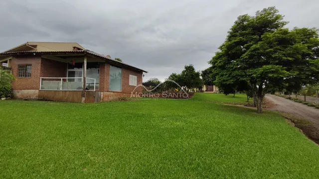 Fachada de uma casa de tijolos com gramado verde bem cuidado em Lajeado.
