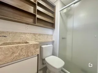 Foto de um banheiro com bancada e vaso sanitário.