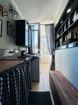 Foto de uma área interna com armários escuros e cortinas estampadas.