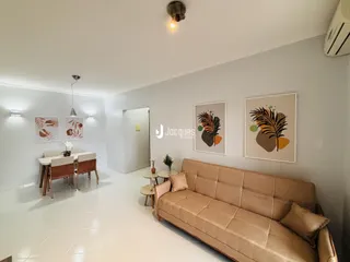 Sala de estar com sofá e mesa de jantar em ambiente claro.