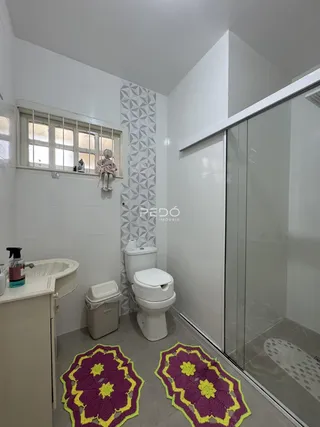 Foto de um banheiro com revestimento decorativo e piso claro.