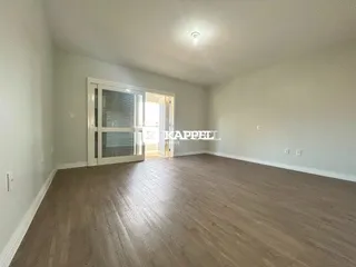 Foto de um cômodo interno com piso de madeira e portas de vidro.