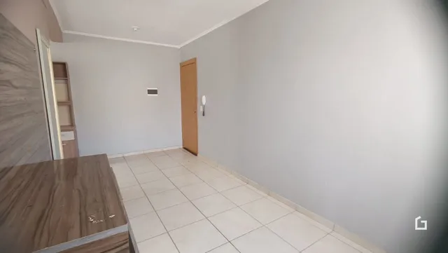 Hall de entrada com piso de cerâmica e porta de madeira clara.