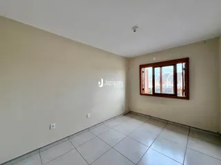 Interior de uma sala vazia com piso de cerâmica e janela.