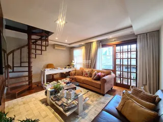 Sala de estar com piso de madeira e grandes janelas.