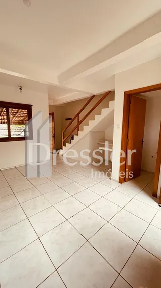 Hall de entrada com piso de cerâmica e escadaria em um imóvel.