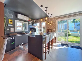 Ambiente de sala de estar com ilha e acesso a um pátio.