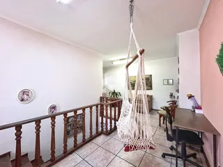 Vista de um corredor com grade de madeira em uma residência no Brasil.