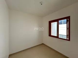 Interior de uma sala de estar com paredes brancas e piso de cerâmica.