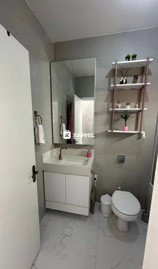 Banheiro com bancada branca e piso de porcelanato claro.