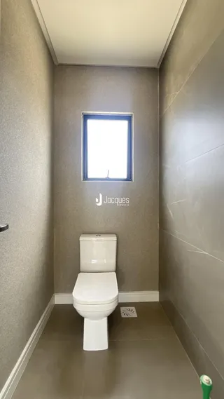 Corredor interno com porta e janela em uma residência.