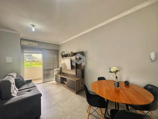 Sala de estar com sofá, mesa de jantar e vista para o exterior.