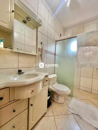 Banheiro com bancada e box de vidro.