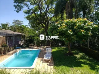 Foto da piscina externa com área gramada e vegetação em Lajeado.