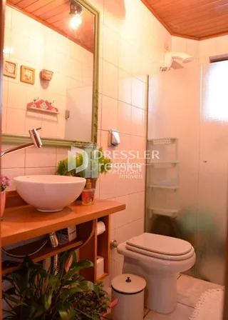 Foto de um banheiro interno com azulejos brancos e louças sanitárias.