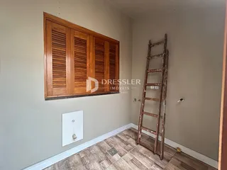 Interior de um cômodo com painel de madeira e piso de madeira.