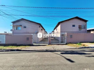 Vista externa de duas casas residenciais em Lajeado, Brasil, com cerca frontal.