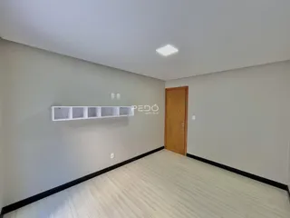 Ambiente interno de uma sala com paredes cinzas e piso claro.