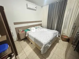 Quarto com cama e armário de madeira em um imóvel.