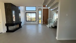 Sala de estar ampla com lareira e grandes janelas.