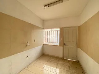 Hall de corredor com piso de cerâmica e paredes claras.