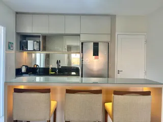 Cozinha moderna com armários brancos e bancadas escuras.