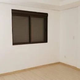 Foto de um cômodo interno com piso de madeira e janela.