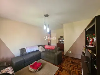 Sala de estar com sofá e piso de madeira.