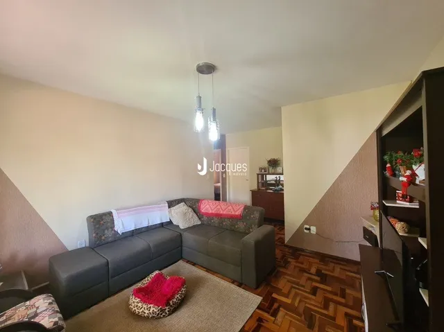 Sala de estar com sofá e piso de madeira.